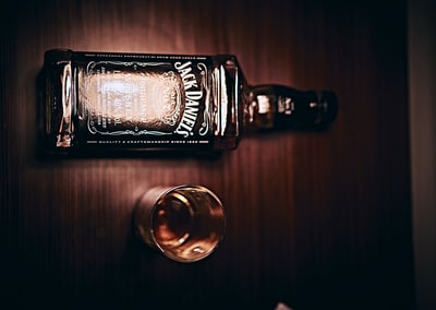 杰克丹尼瓶子旁边清楚饮用玻璃杯

